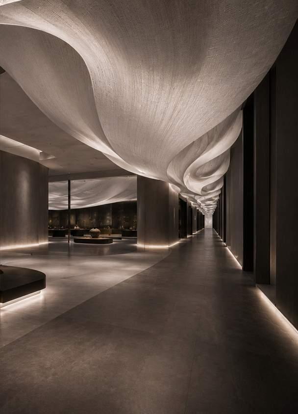 A white paper-like ribbon flowing along a corridor ceiling